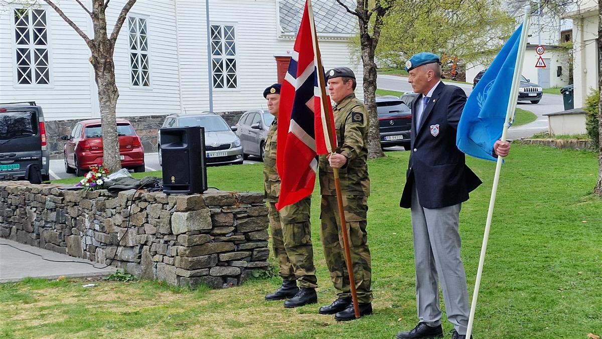 To militære med norsk flagg og ein veteran med FN-flagget. - Klikk for stort bilete