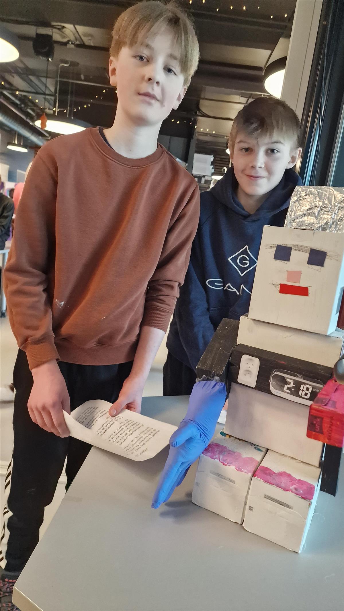 To unge entreprenørar saman med prototypen av robotvekkarklokka si. - Klikk for stort bilete